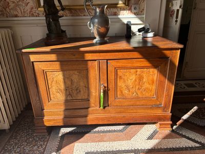 a wooden cabinet with a vase on top of it