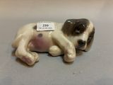 a figurine of a dog laying down on a table