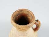 a brown vase with a handle on a white surface