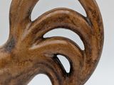 a wooden sculpture of a rooster on a white surface