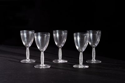 four empty wine glasses are lined up on a black table