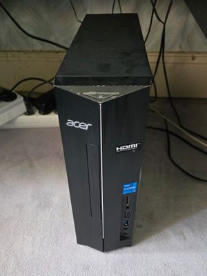 un ordinateur de bureau noir posé par terre sous un bureau