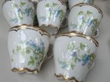 six cups with flowers on them sitting on a table