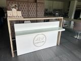 a white counter with a sign on it in the middle of a room