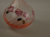 a glass vase with pink flowers on it sitting on a table