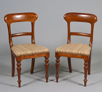 two wooden chairs with upholstered seats on a grey background