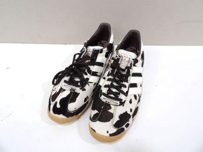 the black and white sneakers are sitting on a white surface