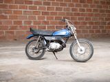 a blue motorcycle parked in front of a brick wall