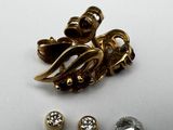 two pairs of earrings and a pair of studs on a white surface