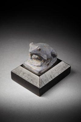 sculpture of a cat on a pedestal with a black background