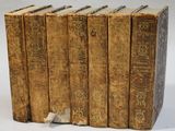 six vieux livres empilés les uns sur les autres sur une surface blanche