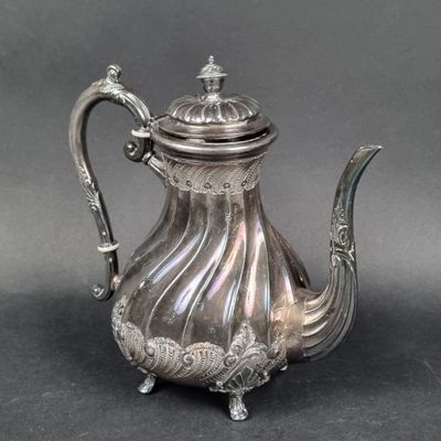 une théière en argent avec une anse sur une table