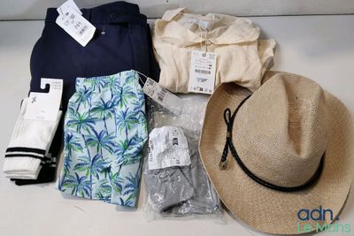 un chapeau, une chemise, un pantalon et d'autres articles disposés sur une table