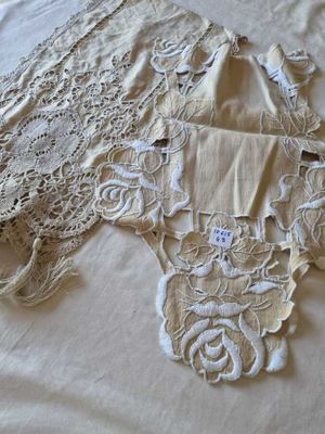 a piece of lace on a bed with a white comforter
