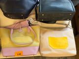 many different purses sitting on a table with price tags