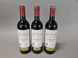 three bottles of wine sitting on top of a table next to each other