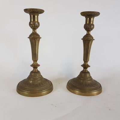 paire de chandeliers anciens en laiton sur fond blanc