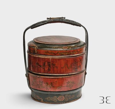 une boîte rouge et noire munie d'une poignée, sur fond blanc