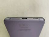 the back of a purple cell phone sitting on top of a table