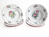 two plates with flowers on them on a white surface