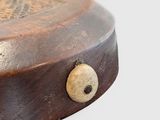 a small wooden object with a button on it
