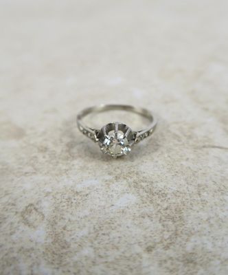 une photo d'une bague en diamant posée sur une surface en marbre