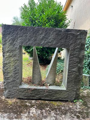 a stone sculpture that is sitting in the middle of the yard