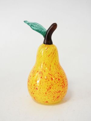 a small yellow and red ceramic pear on a white surface