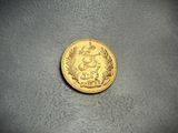 a close up of a gold coin on a gray surface