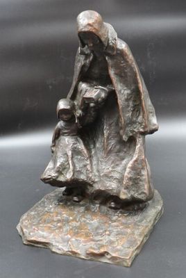 bronze statue of a woman holding a child on a rock