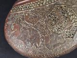 a brown purse with a design on it on a black surface