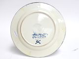 a white plate with blue writing on it on a white surface