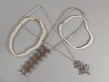 plusieurs colliers et bracelets posés sur une table avec un fond blanc