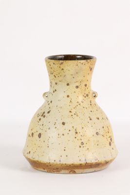 un vase blanc parsemé de taches marron sur un fond blanc