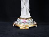 a statue of a woman holding a cross on a plate