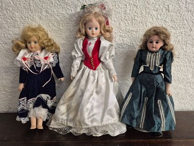 trois poupées assises sur une table