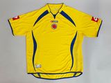 the shirt is yellow with blue trims and a red and white stripe