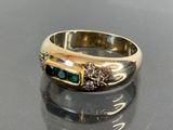 an image of a gold ring with emerald stones
