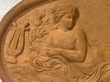 a statue of a woman holding a harp on a wall