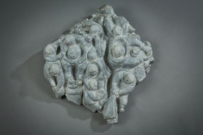 a stone sculpture of a group of people on a wall