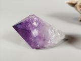 purple amethorate on a white surface with a shell in the background