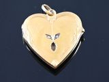 a gold heart shaped locke with a bird on it