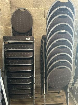 Plusieurs chaises empilables sont empilées sur une palette dans un entrepôt