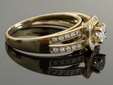 an image of a gold ring with diamonds on a black surface