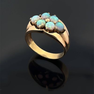 a close up of a gold ring with oplites on a black surface