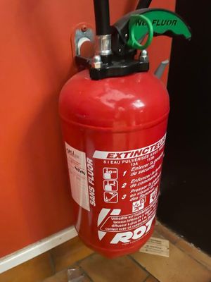 un extincteur fixé au mur d'une pièce
