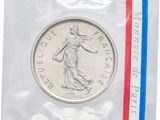 un gros plan d'une pièce de monnaie dans un sachet en plastique orné d'une bande rouge, blanche et bleue