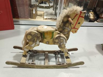 un cheval à bascule en bois exposé dans une vitrine