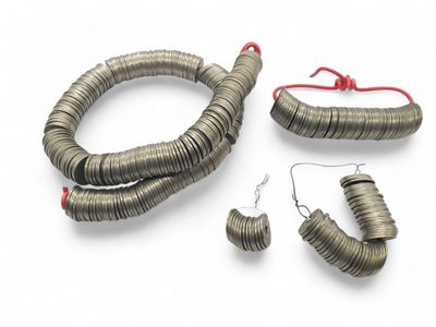 an assortment of silver colored jewelry on a white surface
