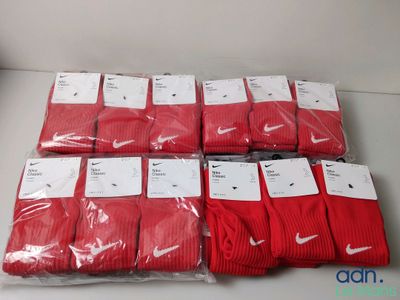 plein de chaussettes Nike rouges posées sur une table blanche